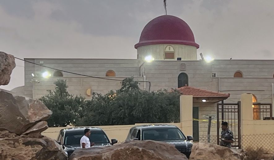 A security officer stands guard a Greek Orthodox Church where gunmen opened fire during a funeral earlier in Hamoud village, in Jordan's Karak governorate, Friday, Oct. 23, 2026. (AP Photo)