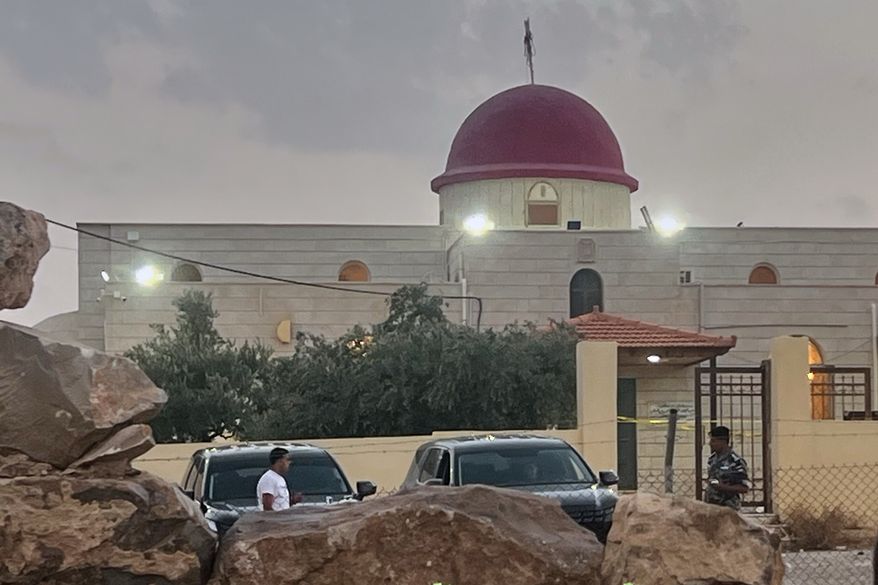 A security officer stands guard a Greek Orthodox Church where gunmen opened fire during a funeral earlier in Hamoud village, in Jordan's Karak governorate, Friday, Oct. 23, 2026. (AP Photo)