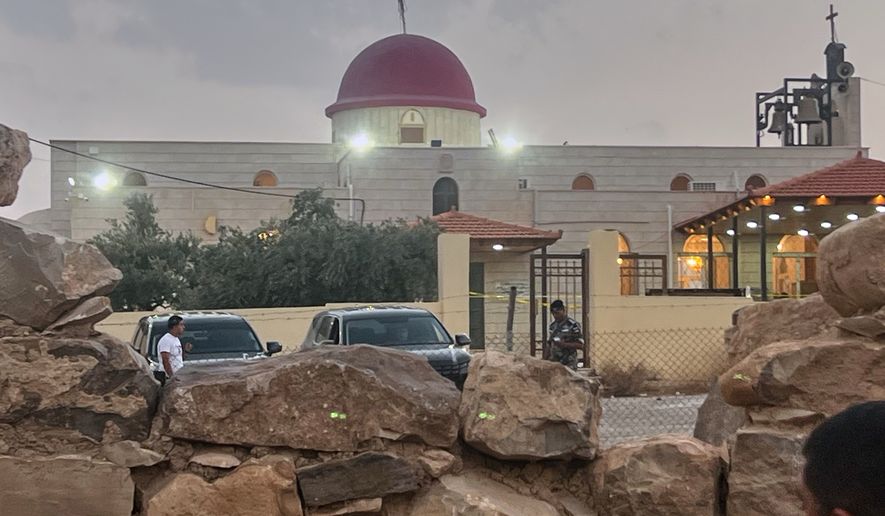 A security officer stands guard outside a Greek Orthodox Church where gunmen opened fire during a funeral earlier in Hamoud village, in Jordan's Karak governorate, Friday, Oct. 23, 2026. (AP Photo)