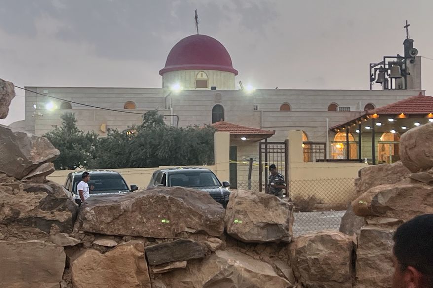 A security officer stands guard outside a Greek Orthodox Church where gunmen opened fire during a funeral earlier in Hamoud village, in Jordan's Karak governorate, Friday, Oct. 23, 2026. (AP Photo)