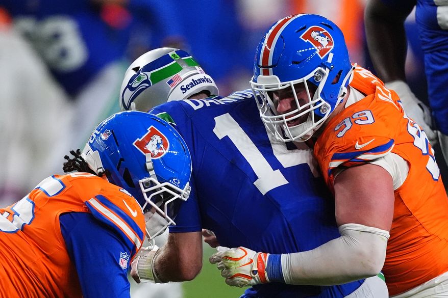 Denver Broncos defensive end Zach Allen (99) sacks Seattle Seahawks quarterback Sam Darnold (14) with Broncos linebacker Nik Bonitto, left, during the second half of an NFL football game in Denver, Thursday, Oct. 15, 2026. (AP Photo/David Zalubowski)