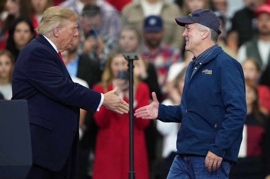 President Donald Trump greets Sen. Dan Sullivan, R-Alaska, at a campaign rally at the Curtis D. Menard Memorial Sports Center, Tuesday, Oct. 13, 2026, in Wasilla, Alaska. (AP Photo/Lindsey Wasson)
