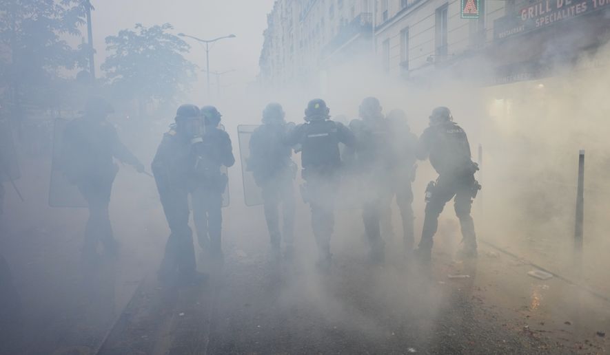 Police officers run toward protesters during a demonstration against rising living costs in Paris, Saturday, Oct. 24, 2026. (AP Photo/Thibault Camus)
