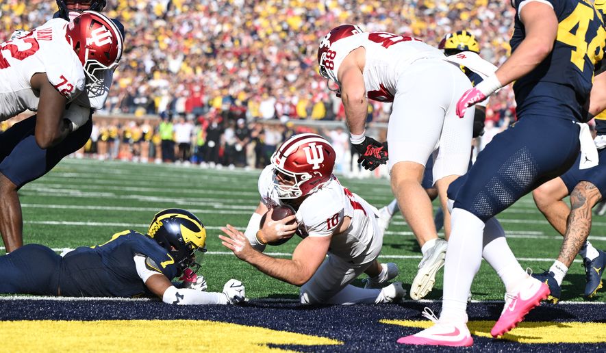 Indiana quarterback Josh Hoover (10) scores a touchdown during overtime in an NCAA college football game against Michigan, Saturday, Oct. 24, 2026, in Ann Arbor, Mich. (AP Photo/Lon Horwedel)