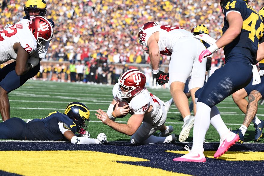 Indiana quarterback Josh Hoover (10) scores a touchdown during overtime in an NCAA college football game against Michigan, Saturday, Oct. 24, 2026, in Ann Arbor, Mich. (AP Photo/Lon Horwedel)