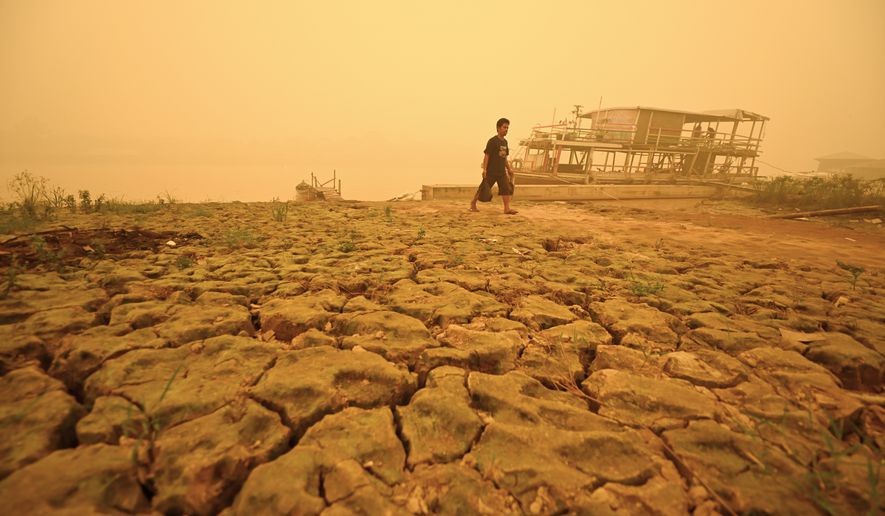 A man walks amid thick haze from wildfires in Palangkaraya, Central Kalimantan, Indonesia, Saturday, Oct. 24, 2026. (AP Photo/Yulianus Stefan Lundju)