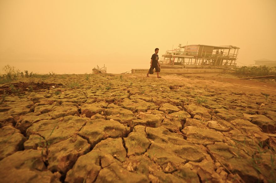 A man walks amid thick haze from wildfires in Palangkaraya, Central Kalimantan, Indonesia, Saturday, Oct. 24, 2026. (AP Photo/Yulianus Stefan Lundju)