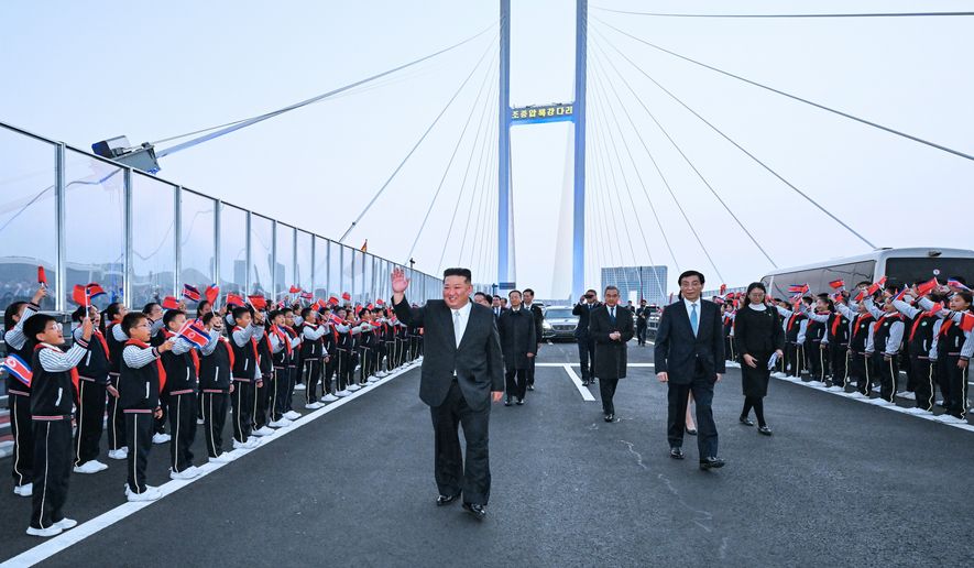 In this photo released by Xinhua News Agency, North Korean leader Kim Jong Un, left, is accompanied by Wang Huning, a member of the Standing Committee of China's Communist Party, second right, and Chinese Foreign Minister Wang Yi, third right, during a see-off ceremony at the new Yalu River Bridge, that connects the two countries, after Kim's visit to Dandong, northeast China's Liaoning Province on Saturday, Oct. 24, 2026. (Rao Aimin/Xinhua via AP)