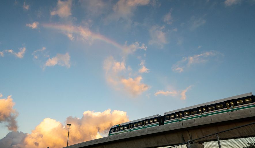 A rainbow arches over a Honolulu Skyline train at sunset, Sept. 19, 2024, in Honolulu. (AP Photo/Mengshin Lin, File)