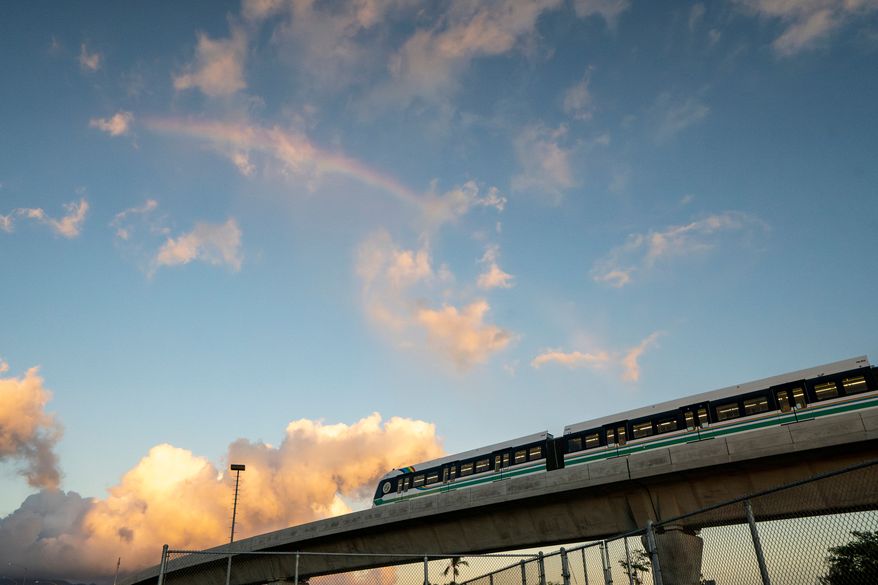A rainbow arches over a Honolulu Skyline train at sunset, Sept. 19, 2024, in Honolulu. (AP Photo/Mengshin Lin, File)