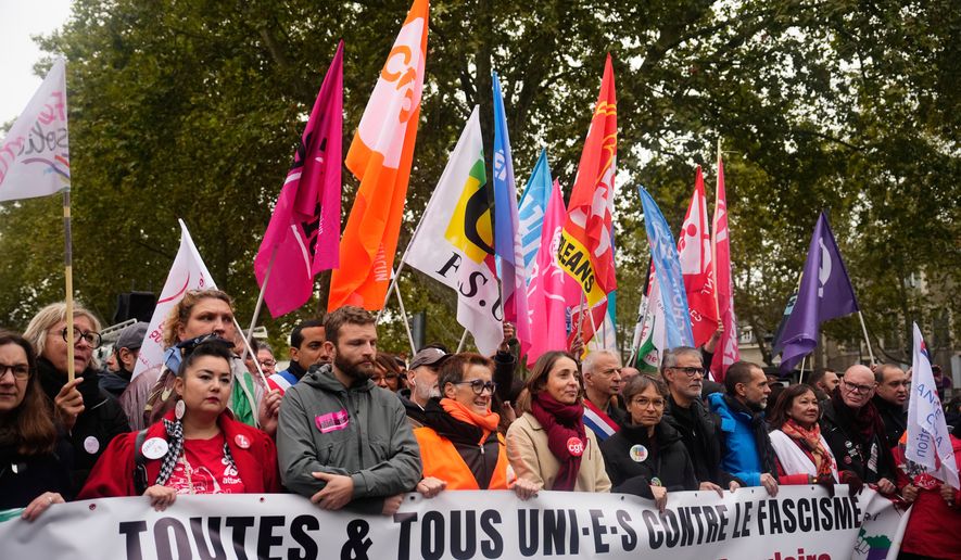 Leftists unions and political parties members hold a banner reading "all united against fascism. For the popular rally and social progress" during a protest on the sidelines of the far-right party Rassemblement National (RN) congress, in Orleans, France, Saturday, Oct. 24, 2026. (AP Photo/Teresa Suarez)