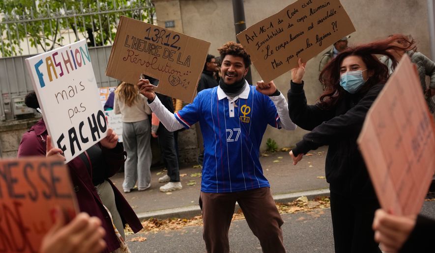 Protesters hold signs reading “Fashion but not fascist” and “Time for revolution” during a protest on the sidelines of the far-right Rassemblement National (RN) Congress in Orléans, France, Saturday, Oct. 24, 2026. (AP Photo/Teresa Suarez)