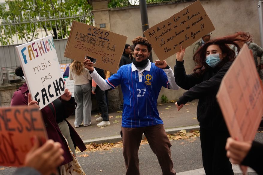 Protesters hold signs reading “Fashion but not fascist” and “Time for revolution” during a protest on the sidelines of the far-right Rassemblement National (RN) Congress in Orléans, France, Saturday, Oct. 24, 2026. (AP Photo/Teresa Suarez)