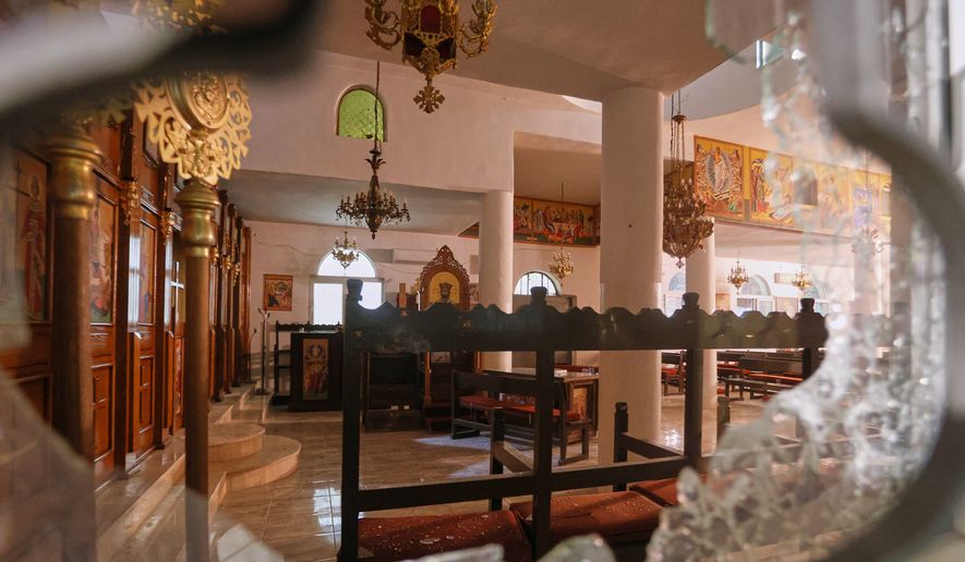 The interior of a Greek Orthodox church is seen through a shattered window hours after gunmen opened fire during a funeral, in Hamoud village, in Jordan's Karak governorate, Friday, Oct. 23, 2026. (AP Photo)