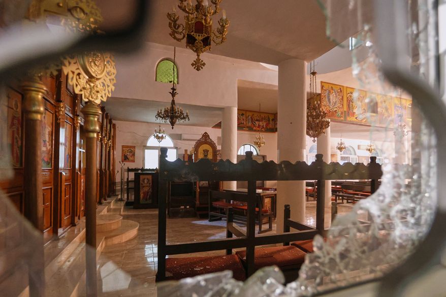 The interior of a Greek Orthodox church is seen through a shattered window hours after gunmen opened fire during a funeral, in Hamoud village, in Jordan's Karak governorate, Friday, Oct. 23, 2026. (AP Photo)