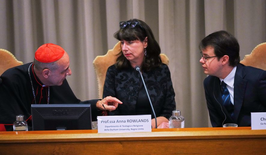 From left, Cardinal Víctor Manuel Fernández, prefect of the Dicastery for the Doctrine of the Faith, talks with theologian Anna Rowlands, and Anthropic co-founder Christopher Olah during the presentation of Pope Leo XIV's first encyclical, "Magnifica humanitas: On Safeguarding the Human Person in the Time of Artificial Intelligence," at the Vatican, May 25, 2026. (AP Photo/Alessandra Tarantino, File)