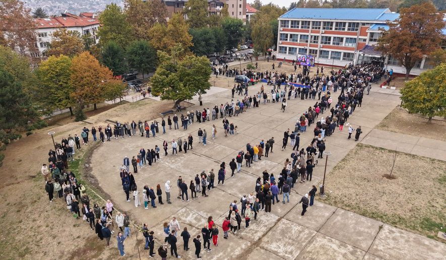 People wait in lines outside a polling station to cast their votes during a parliamentary election in Belgrade, Serbia, Sunday, Oct. 25, 2026. (AP Photo/Armin Durgut)