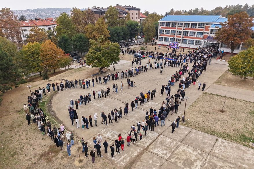 People wait in lines outside a polling station to cast their votes during a parliamentary election in Belgrade, Serbia, Sunday, Oct. 25, 2026. (AP Photo/Armin Durgut)