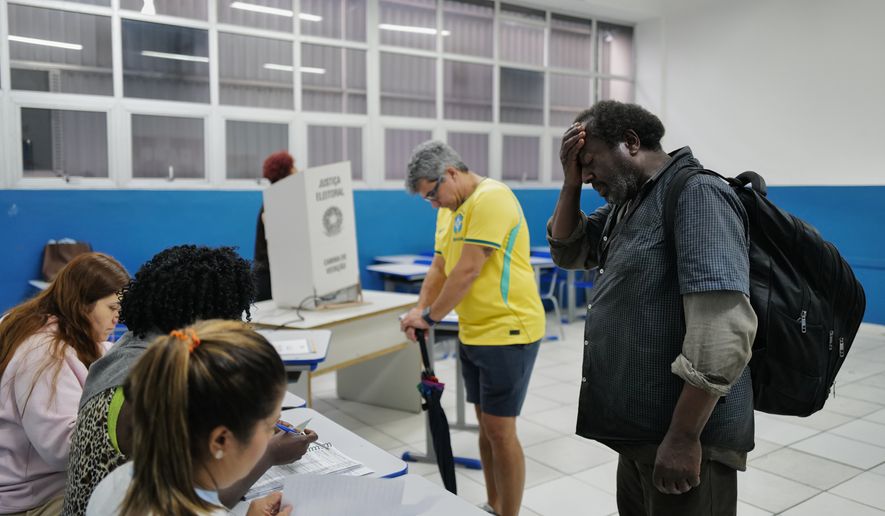 Voters wait to cast their ballots during a presidential runoff in Rio de Janeiro, Sunday, Oct. 25, 2026. (AP Photo/Lucas Landau)