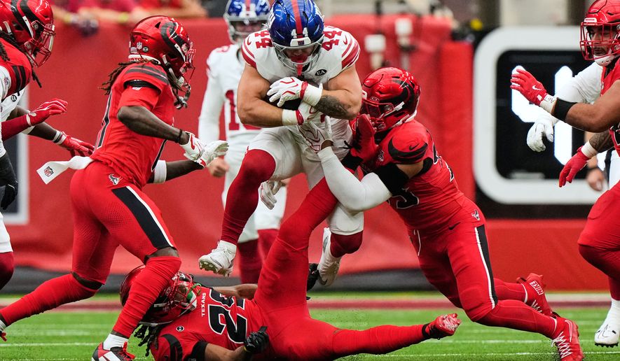 New York Giants running back Cam Skattebo (44) leaps over Houston Texans safety M.J. Stewart (29) and is tackled by linebacker Henry To'oto'o, right, during the first half of an NFL football game in Houston, Sunday, Oct. 25, 2026. (AP Photo/Gerald Herbert)