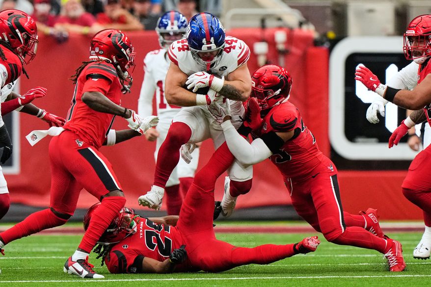 New York Giants running back Cam Skattebo (44) leaps over Houston Texans safety M.J. Stewart (29) and is tackled by linebacker Henry To'oto'o, right, during the first half of an NFL football game in Houston, Sunday, Oct. 25, 2026. (AP Photo/Gerald Herbert)