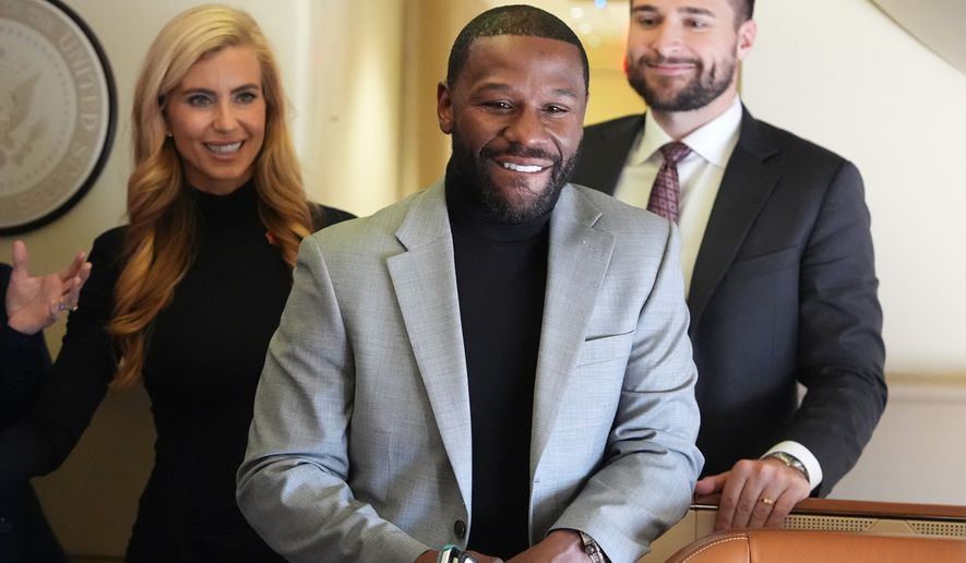 Floyd Mayweather, Jr., stands with White House press secretary Katie Zacharia, left, on Air Force One before a campaign rally with President Donald Trump at Laughlin Bullhead International Airport, Wednesday, Oct. 14, 2026, in Bullhead, Ariz. (AP Photo/Alex Brandon)