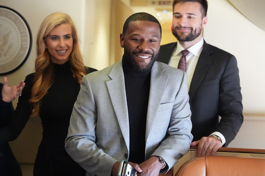 Floyd Mayweather, Jr., stands with White House press secretary Katie Zacharia, left, on Air Force One before a campaign rally with President Donald Trump at Laughlin Bullhead International Airport, Wednesday, Oct. 14, 2026, in Bullhead, Ariz. (AP Photo/Alex Brandon)