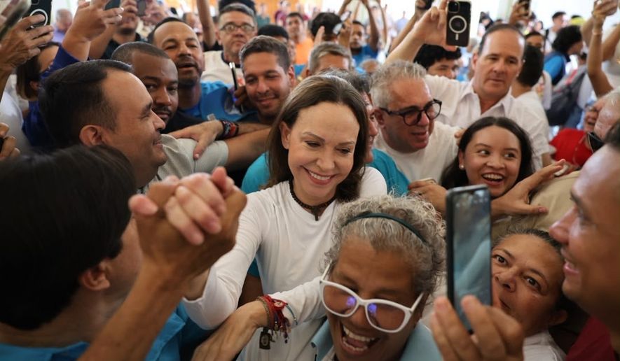 In this photo released by Vente Venezuela Press Office, Venezuelan opposition leader Maria Corina Machado greets supporters at a church in Barquisimeto, Venezuela, Sunday, Oct. 25, 2026. (Vente Venezuela Press Office via AP)