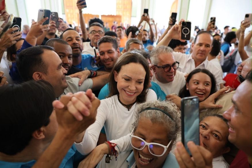 In this photo released by Vente Venezuela Press Office, Venezuelan opposition leader Maria Corina Machado greets supporters at a church in Barquisimeto, Venezuela, Sunday, Oct. 25, 2026. (Vente Venezuela Press Office via AP)