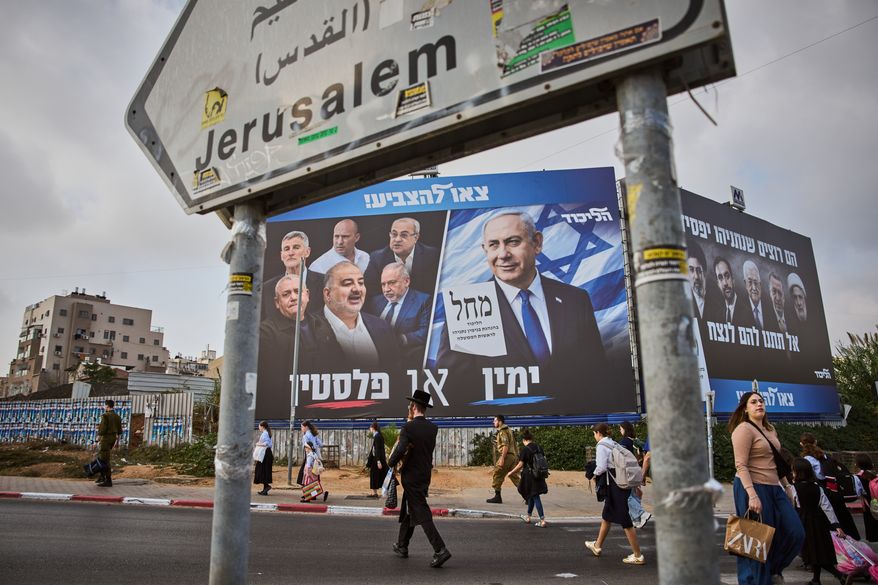 People walk past a Likud party campaign billboard featuring Israeli Prime Minister Benjamin Netanyahu alongside opposition party leaders and bearing the Hebrew slogan "Right or Palestine," ahead of Israel's general election, in Beni Brak, Israel, Sunday, Oct. 25, 2026. (AP Photo/Oded Balilty)