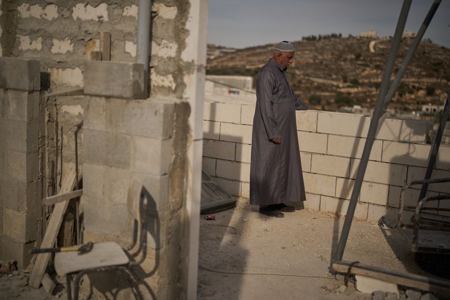 Mahmoud Tubasi stands on a rooftop near his two family's houses, which were burned by Israeli settlers in the West Bank village of Jalud, Tuesday, Oct. 20, 2026. (AP Photo/Leo Correa)