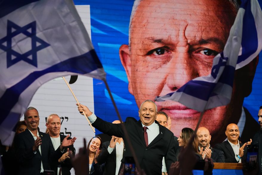 Gadi Eisenkot, leader of the Yashar ("Straight") party, waves an Israeli flag onstage following the release of the first exit poll results in Israel's general election in Tel Aviv, Israel, Wednesday, Oct. 28, 2026. (AP Photo/Ariel Schalit)