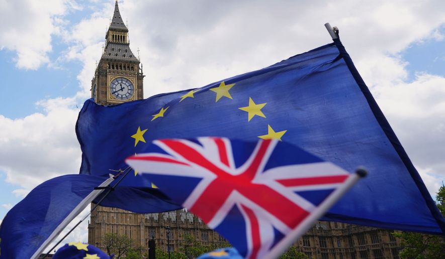 FILE - Pro-European Union campaigners hold flags near parliament as Britain's Prime Minister attends the weekly session of Prime Ministers Questions in London on May 20, 2026. (AP Photo/Kirsty Wigglesworth, File)