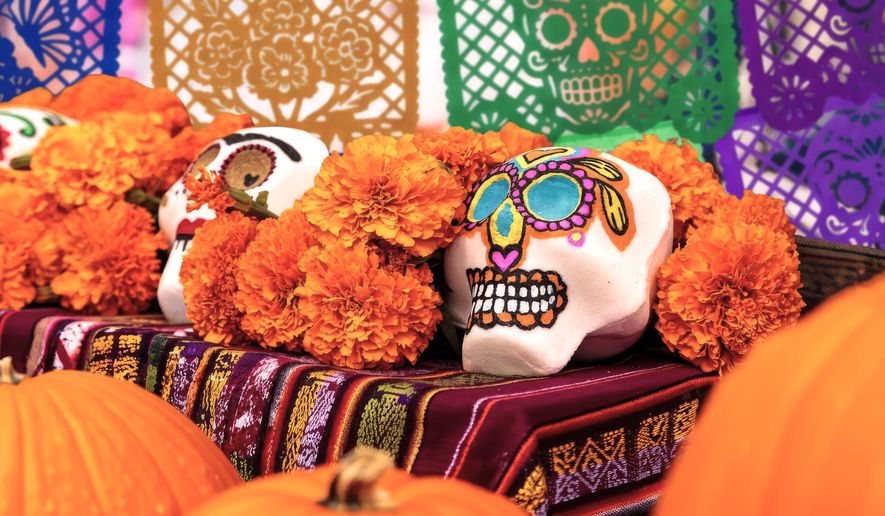 This image provided by the New York Botanical Garden shows a bright marigolds and painted decorative skulls displayed on an alter during the site's Dia de los Muertos celebration in the Bronx borough of New York. (New York Botanical Garden via AP)