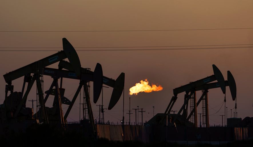 A flare burns off methane and other hydrocarbons as oil pumpjacks operate in the Permian Basin in Midland, Texas, on Oct. 12, 2021. (AP Photo/David Goldman, File)