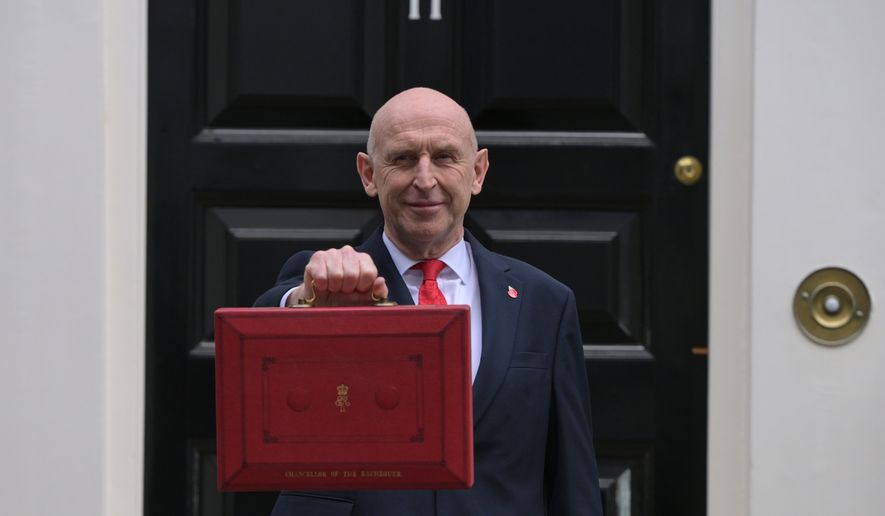 Britain's Chancellor of the Exchequer John Healey poses on the doorstep of 11 Downing Street with the ministerial red box before heading to the House of Commons to deliver the budget statement in London, Wednesday, Oct. 28, 2026.(AP Photo/Thomas Krych)