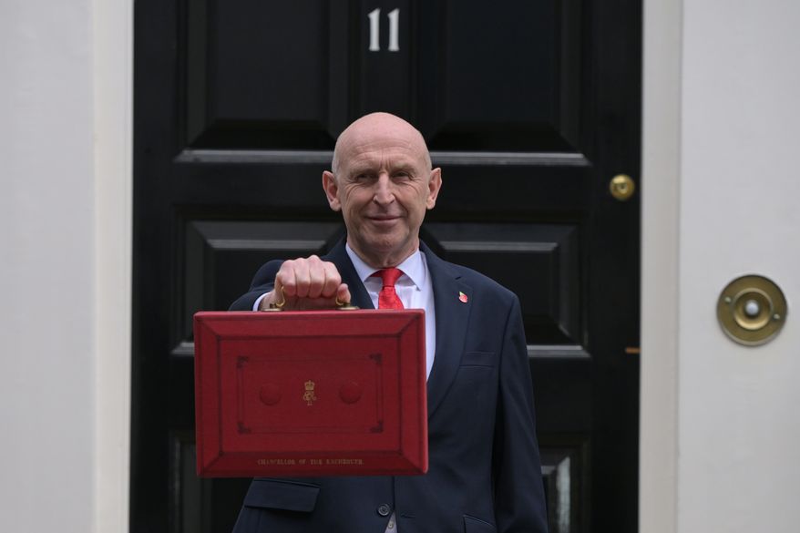 Britain's Chancellor of the Exchequer John Healey poses on the doorstep of 11 Downing Street with the ministerial red box before heading to the House of Commons to deliver the budget statement in London, Wednesday, Oct. 28, 2026.(AP Photo/Thomas Krych)