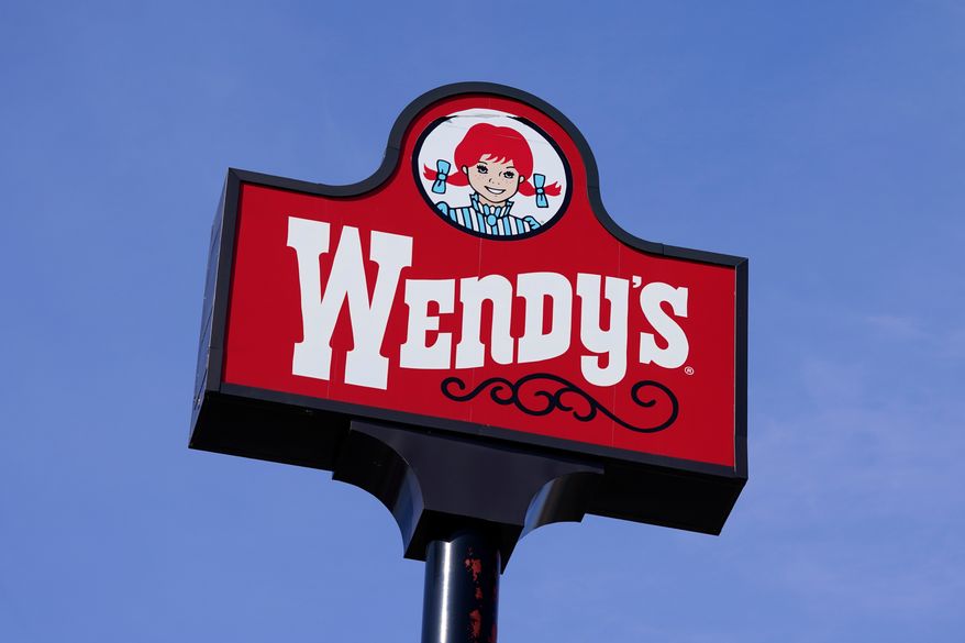 FILE - A sign stands over a Wendy's restaurant, Feb. 25, 2021, in Des Moines, Iowa. (AP Photo/Charlie Neibergall, File)
