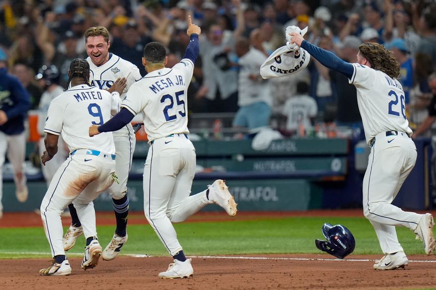 Tampa Bay Rays shortstop Jorge Mateo (9) and right fielder Victor Mesa Jr. (25) celebrate with Tampa Bay Rays second baseman Ben Williamson after his walk-off RBI single during the 12th inning of Game 4 of baseball's World Series, Wednesday, Oct. 28, 2026, in St. Petersburg, Fla., between the Milwaukee Brewers and the Tampa Bay Rays. (AP Photo/Chris O'Meara)