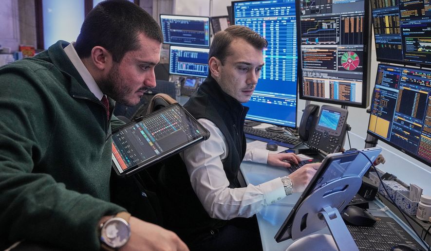 Traders Drew Cohen, left, and Dylan Halvorsan work on the floor of the New York Stock Exchange, Monday, Jan. 26, 2026. (AP Photo/Richard Drew, File)