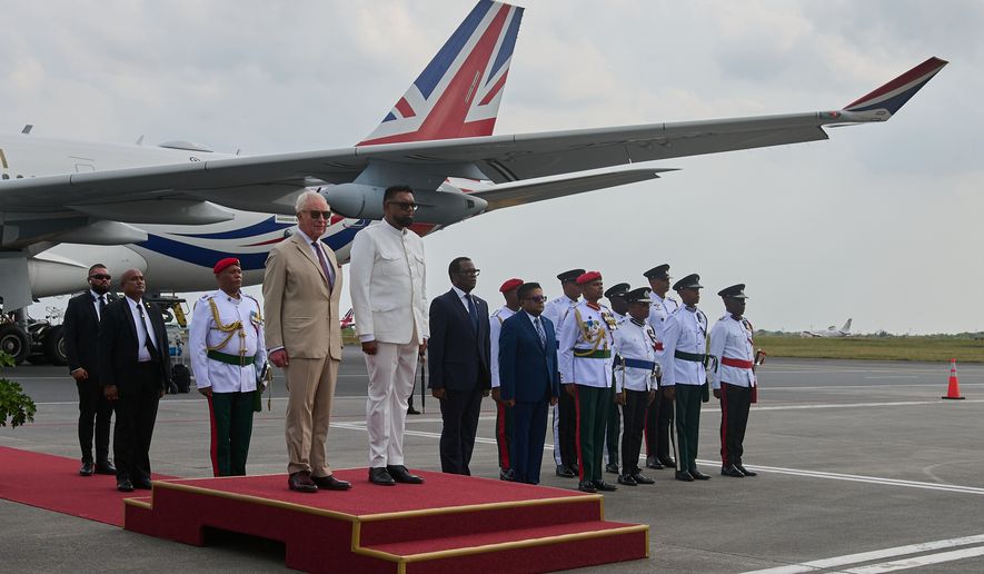 Britain's King Charles III prepares to inspect the guard of honor accompanied by President Mohamed Irfaan Ali, upon his arrival at Cheddi Jagan International Airport in Georgetown, Guyana, Thursday, Oct. 29, 2026. (AP Photo/Delano Williams)