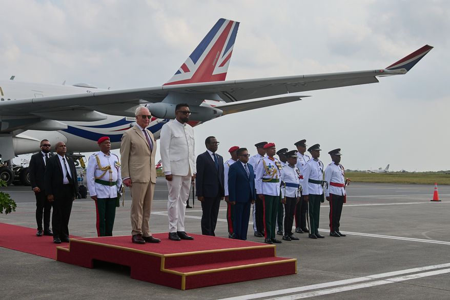 Britain's King Charles III prepares to inspect the guard of honor accompanied by President Mohamed Irfaan Ali, upon his arrival at Cheddi Jagan International Airport in Georgetown, Guyana, Thursday, Oct. 29, 2026. (AP Photo/Delano Williams)
