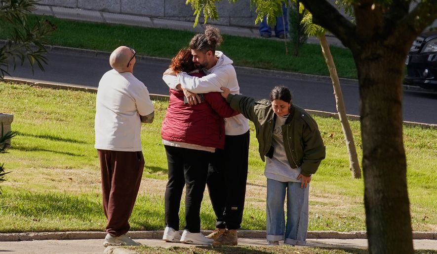People searching for relatives who were traveling on the trains involved in a collision gather at a religious residence converted into a temporary medical facility in Toledo, Spain, Thursday, Oct. 29, 2026. (AP Photo/Andrea Comas)