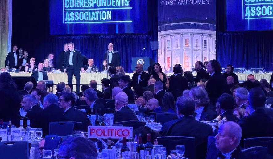 FILE - U.S. Secret Service agents respond near President Donald Trump and first lady Melania Trump during the White House Correspondents Dinner, April 25, 2026, in Washington. (AP Photo/Alex Brandon, File)