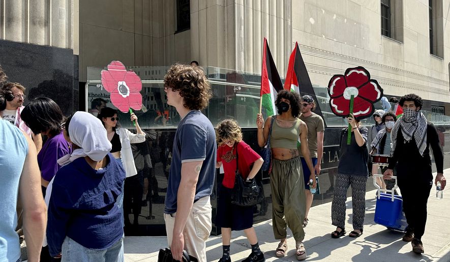 FILE - People carry Palestinian flags outside the federal courthouse in Detroit on Wednesday, June 10, 2026, after activists appeared in court on conspiracy charges. (AP Photo/Ed White, File)
