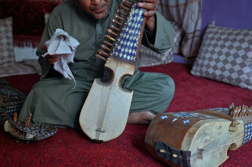 A musician who now works as a manual laborer after closing his family's instrument shop following the Taliban takeover in 2021 holds a rubab, a traditional stringed instrument, in Kabul, Afghanistan, Sunday, Oct. 11, 2026.(AP Photo/Nava Jamshidi)
