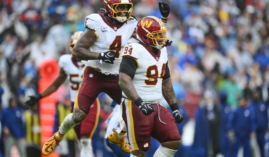 Washington Commanders' Frankie Luvu (4) celebrates with Daron Payne (94) after a defensive stop during the first half of an NFL football game against the New York Giants in Landover, Md., Sunday, Oct. 11, 2026. (AP Photo/Nick Wass)
