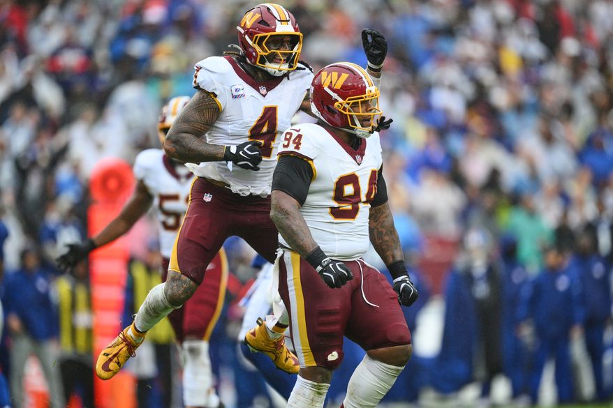 Washington Commanders' Frankie Luvu (4) celebrates with Daron Payne (94) after a defensive stop during the first half of an NFL football game against the New York Giants in Landover, Md., Sunday, Oct. 11, 2026. (AP Photo/Nick Wass)