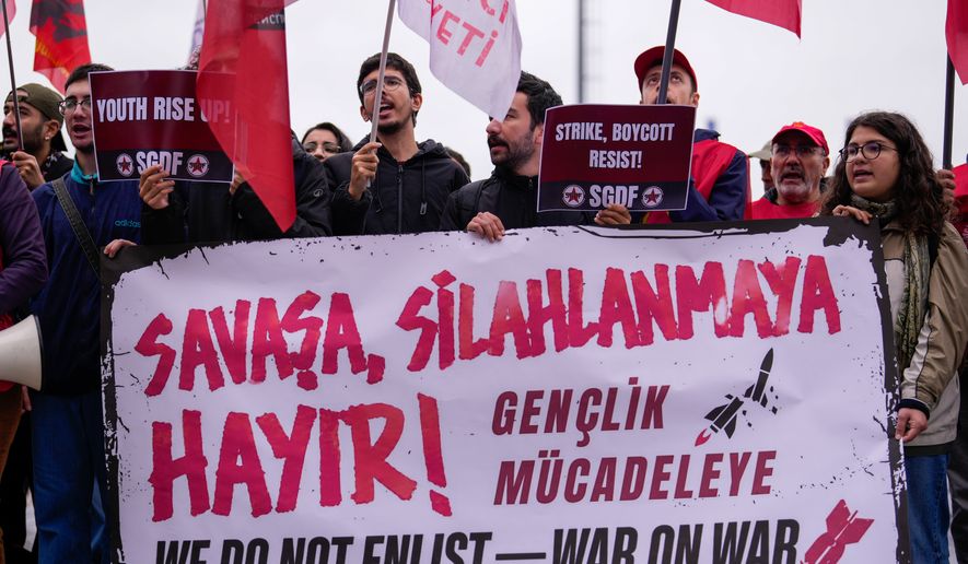 People shout slogans during a protest outside Haydarpasa port calling for the end of shipments to Israel, in Istanbul, Turkey, Friday, Oct. 30, 2026. The banner reads in Turkish: "No to war, no to armament!". (AP Photo/Emrah Gurel)