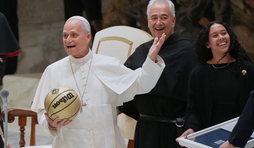From right Villanova basketball player Jasmine Bascoe along with Villanova University President Peter M. Donohue, present Pope Leo XIV with a basketball in the Paul VI Hall at the Vatican, Saturday, Oct. 31, 2026, during an audience with some 7,000 university representatives ahead of the Eternal City Tip-Off, a men's and women's college basketball doubleheader in Rome on Nov. 1. (AP Photo/Gregorio Borgia)